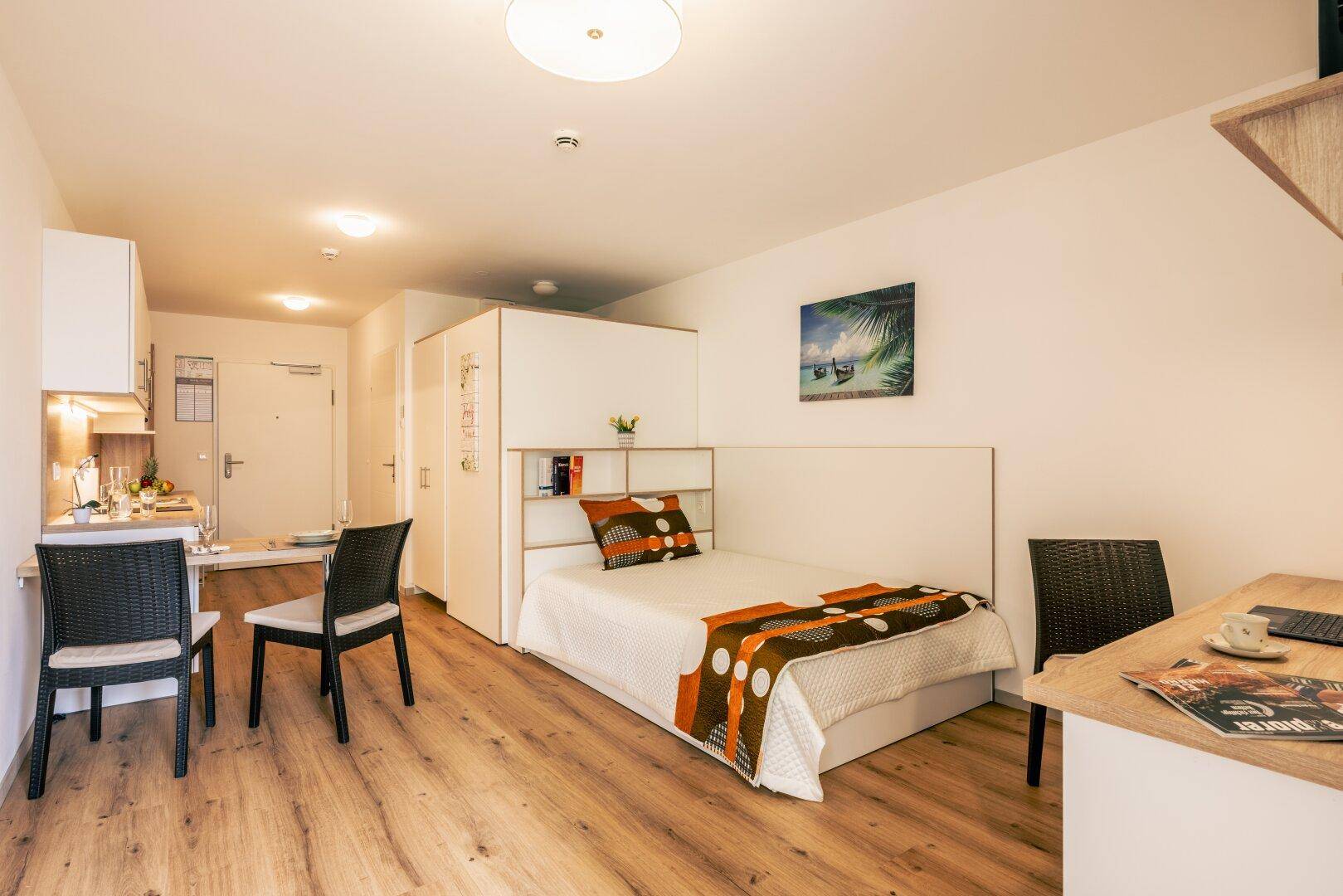 Gemütliches Studio-Apartment mit Schlafbereich, Essplatz und kleiner Küchenzeile.