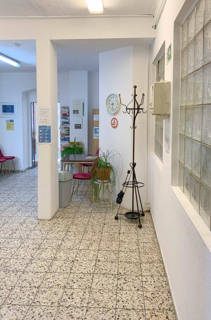 Geräumiger Flur mit gemusterten Fliesen, Garderobe und Glasbausteinen für indirektes Licht.