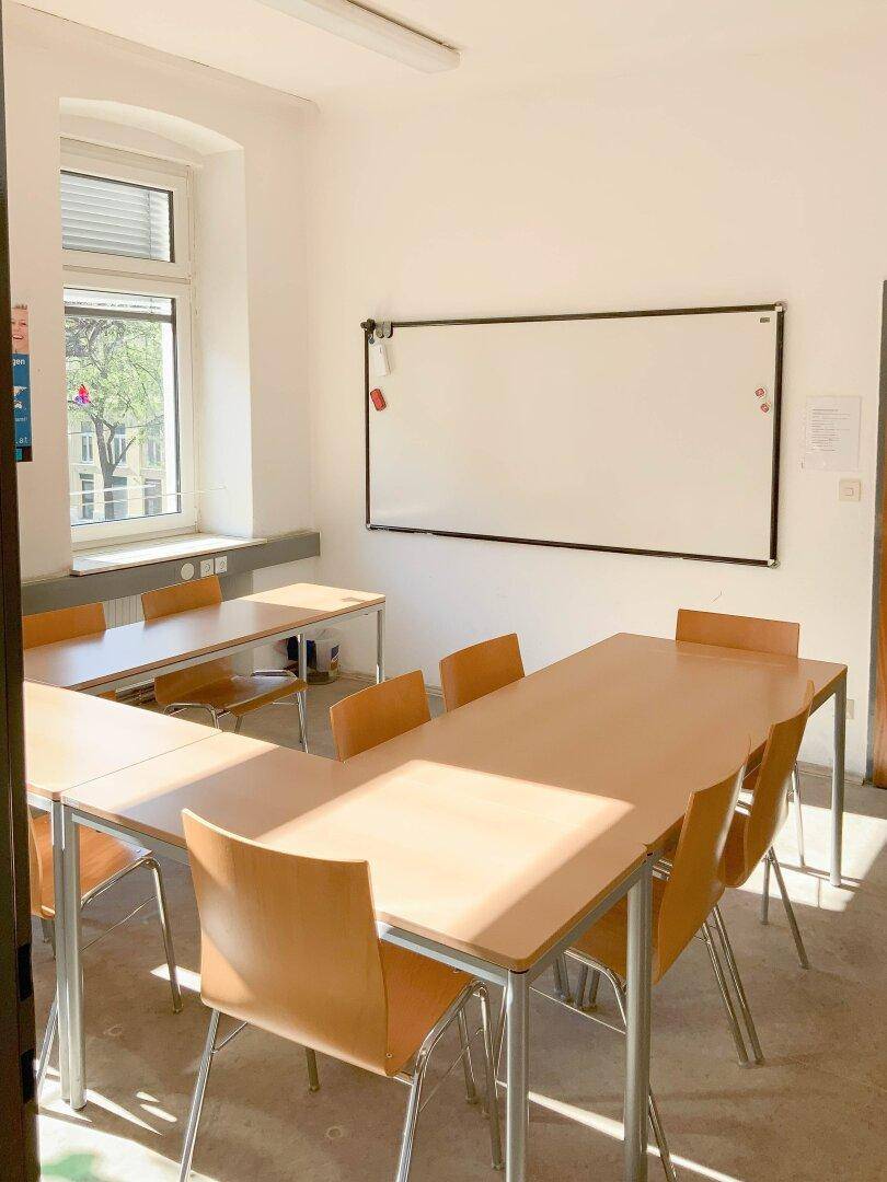 Funktionaler Büroraum mit Whiteboard und Holzboden, ausgestattet für produktives Arbeiten.