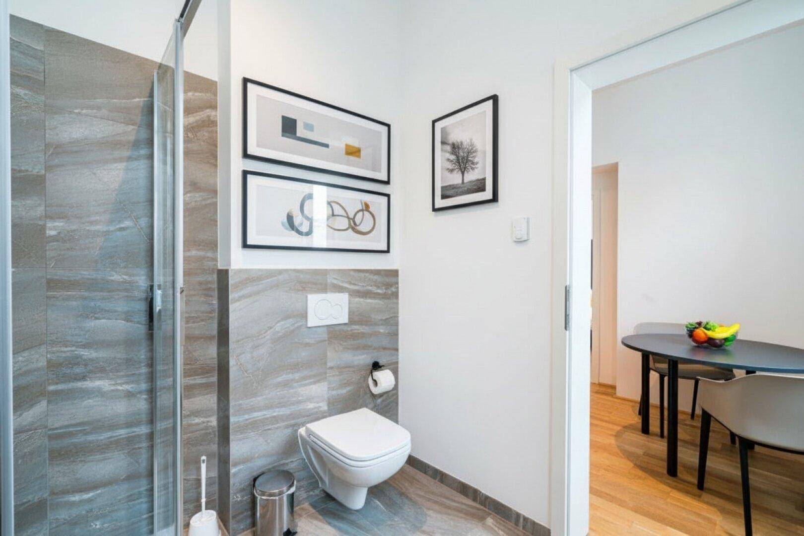 Modernes Badezimmer mit begehbarer Dusche, Wand-WC und stilvollen Fliesen.
