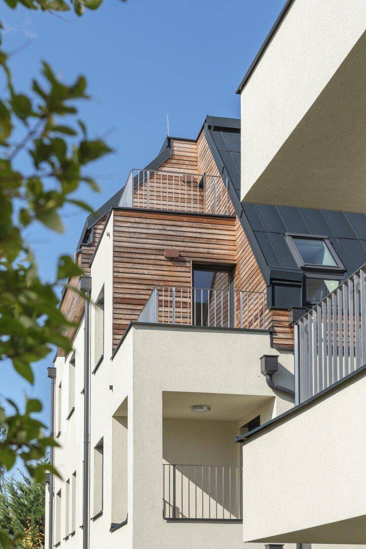 Detailansicht der modernen Architektur mit Holzverkleidung und Dachterrassen.