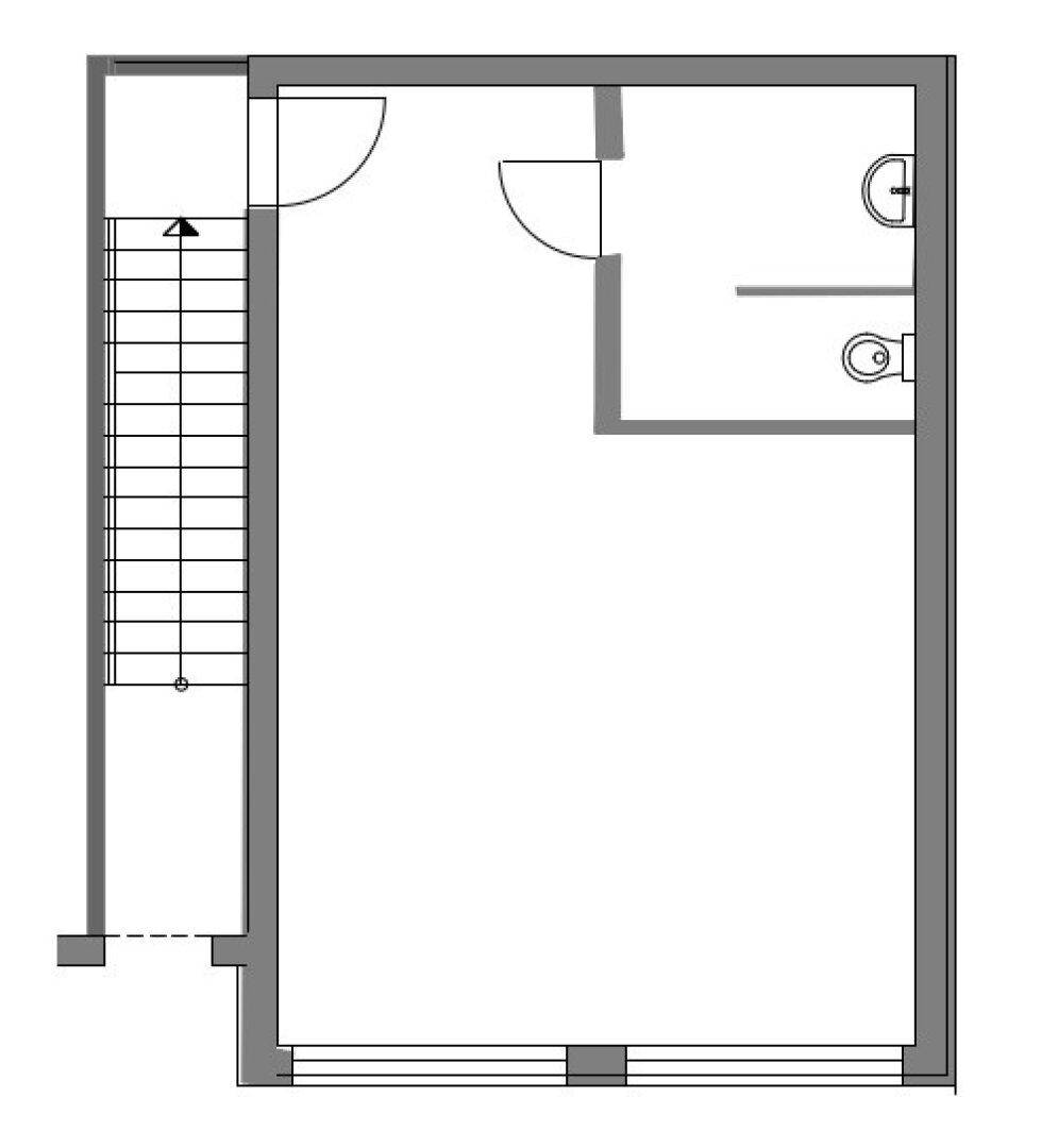 Grundrissplan eines Stockwerks mit Treppenhaus, einem großen Raum und einem Badezimmer.