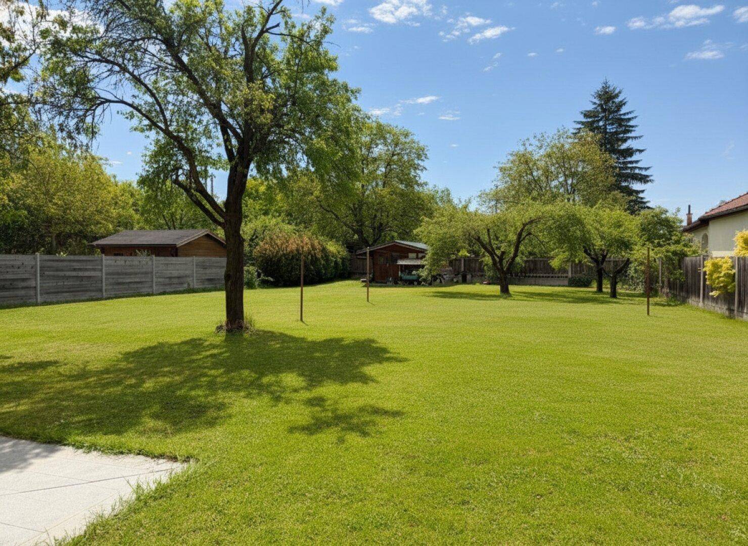 Großer, sonniger Garten mit altem Baumbestand, Rasenfläche und Gartenhäuschen.