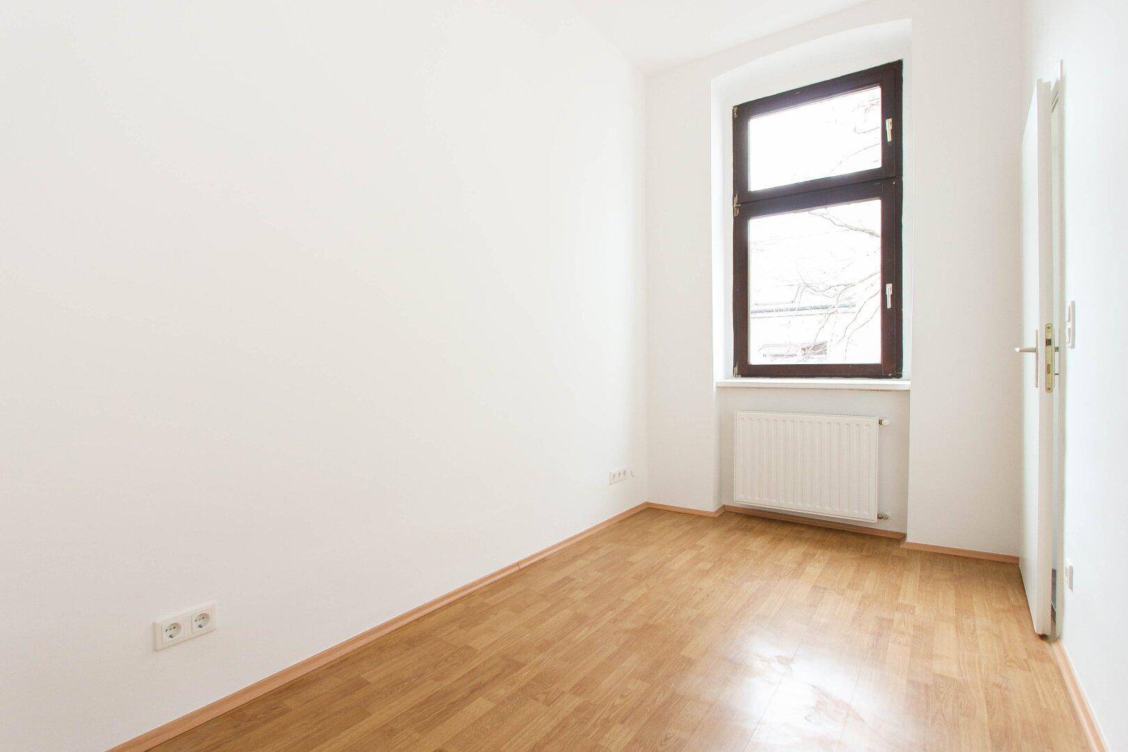 Kleineres, helles Zimmer mit Parkettboden und einem Fenster, ideal als Schlaf- oder Arbeitszimmer.