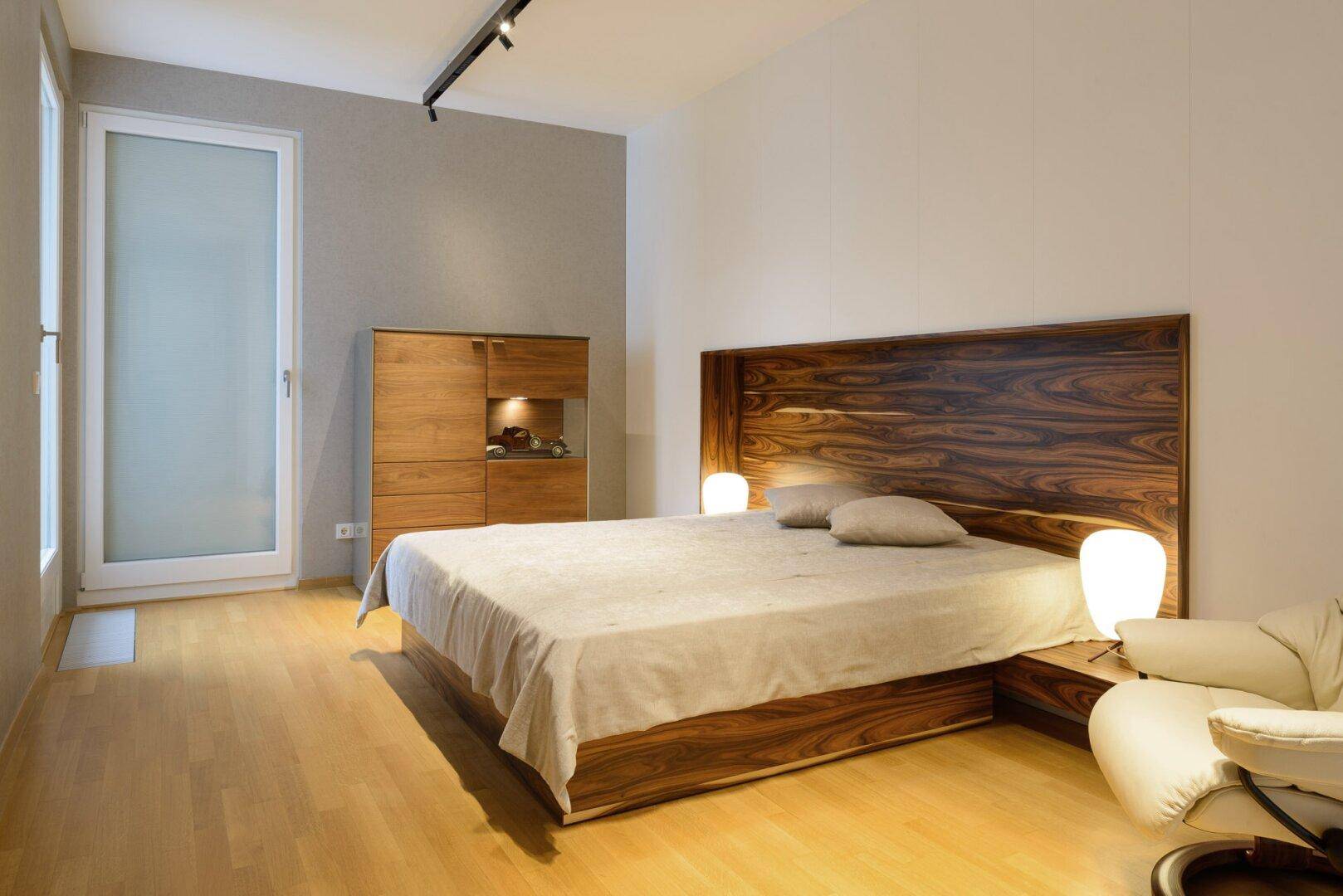 Geräumiges Schlafzimmer mit Holzbett, Holzboden und hellem Ambiente.