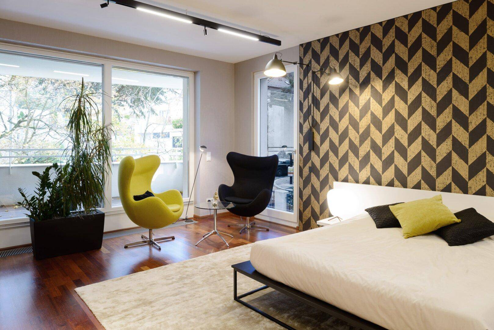 Modernes Schlafzimmer mit gemusterter Wand, Holzboden und Zugang zum Balkon.