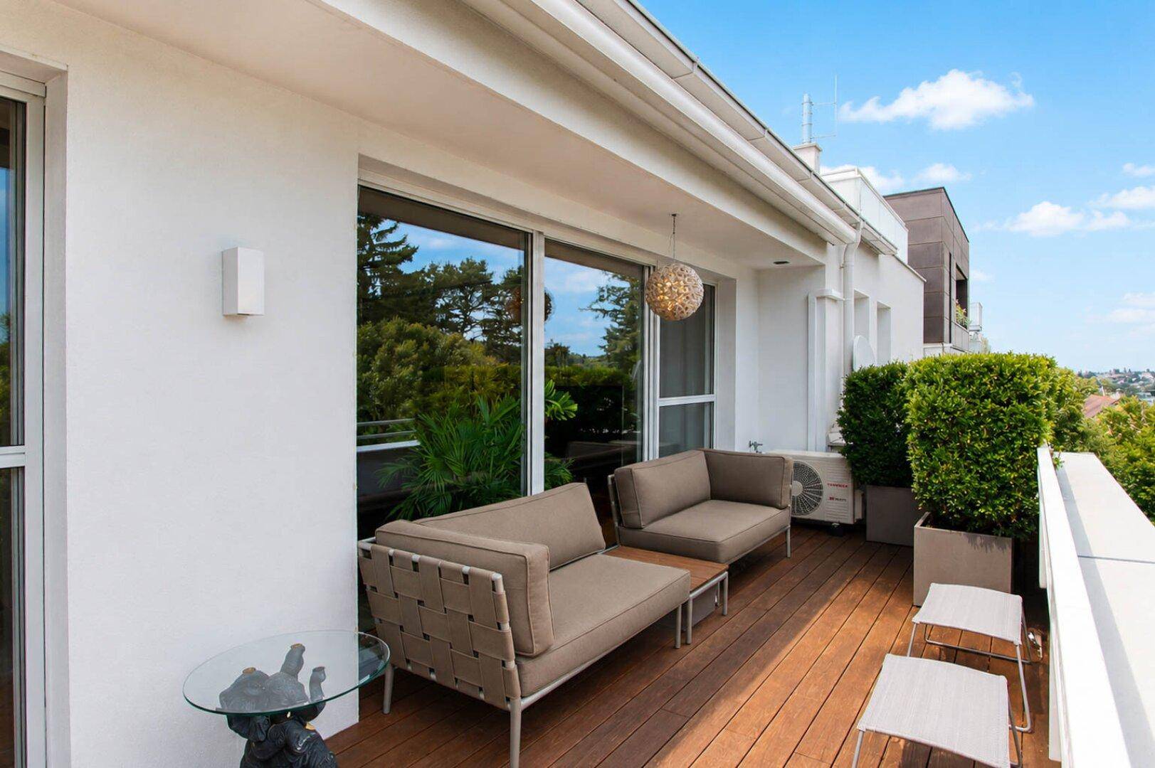Gemütliche Terrasse mit modernen Sitzmöbeln und Blick ins Grüne.