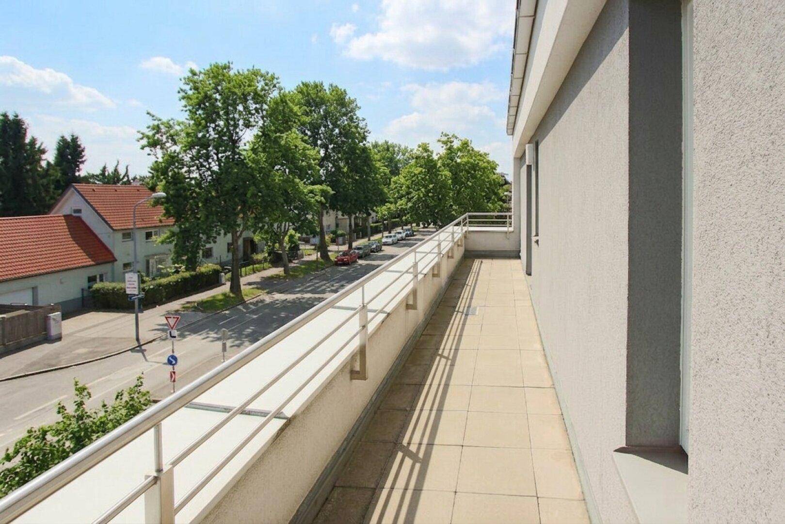 Geräumiger Balkon mit Fliesenboden und Geländer, bietet einen weiten Blick auf die Umgebung.