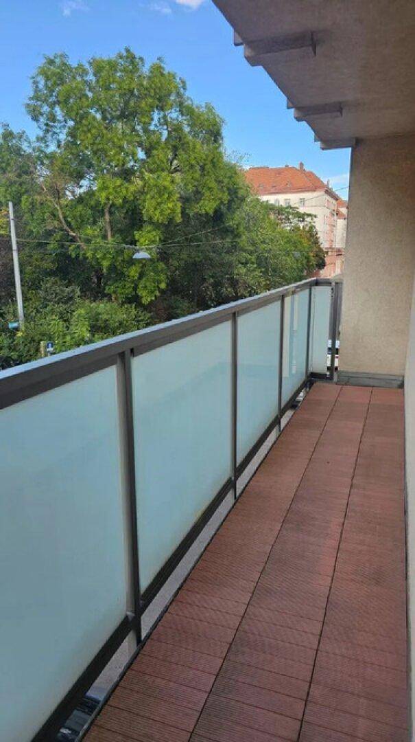Moderner Balkon mit Milchglasgeländer und Blick ins Grüne, ideal zum Entspannen.