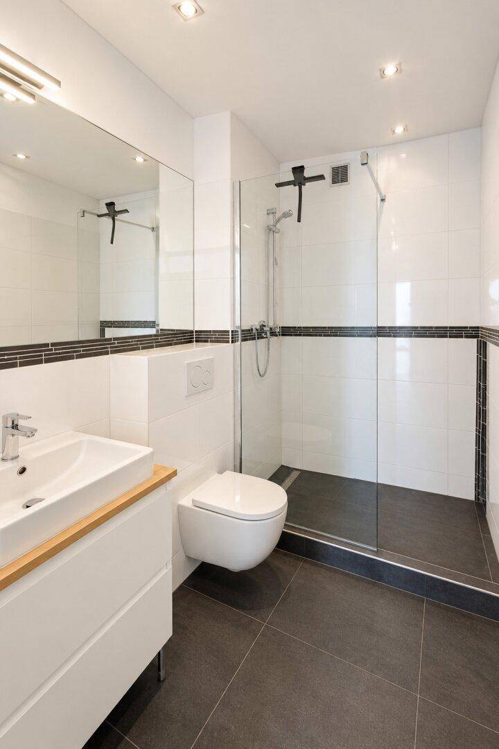 Modernes Badezimmer mit ebenerdiger Dusche, wandhängendem WC und Einzelwaschbecken.
