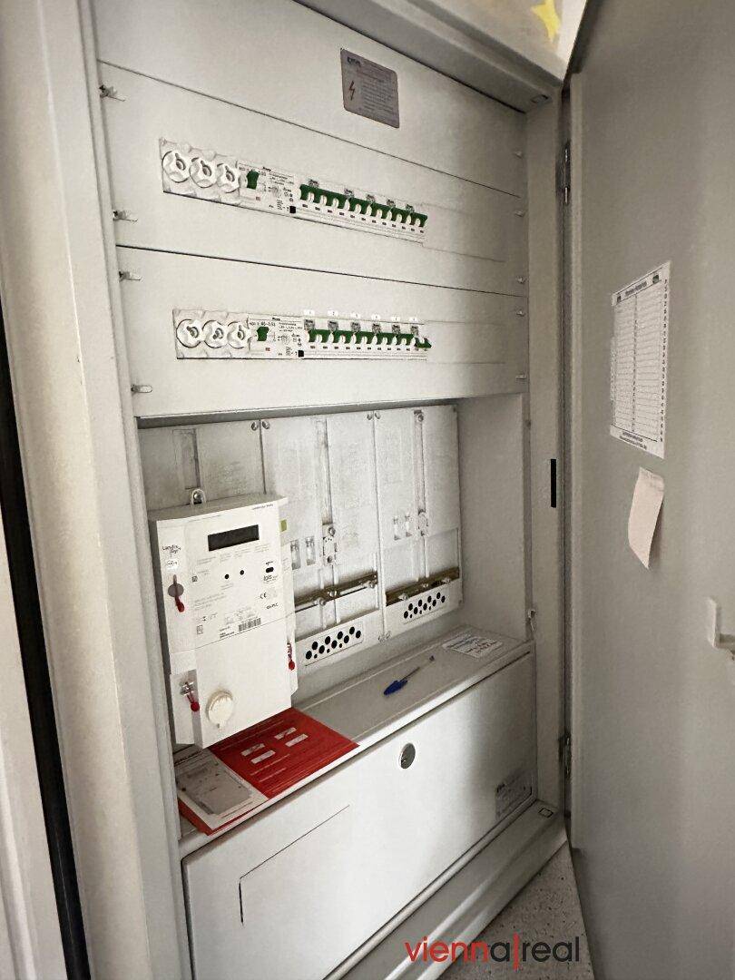 Elektrischer Verteilerkasten mit Zählern und Sicherungen, ordentlich installiert und zugänglich.