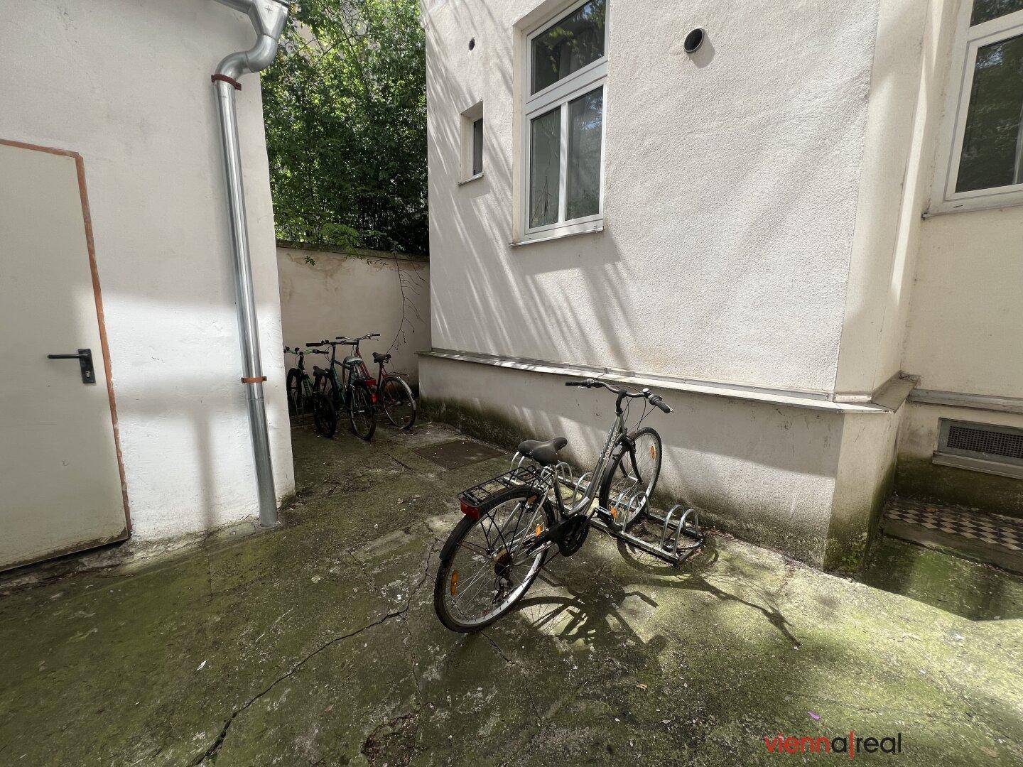 Hinterhofbereich mit Fahrradabstellplätzen und einer schlichten Fassade.