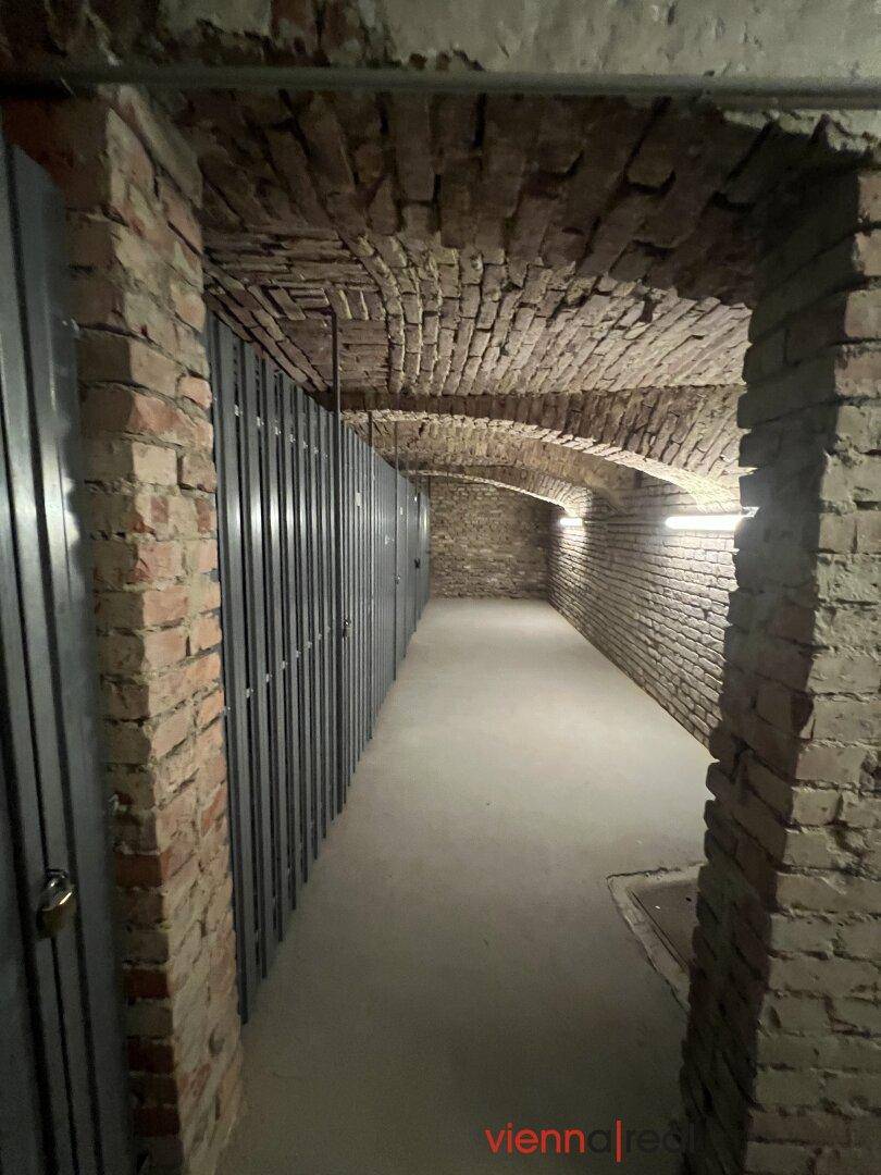 Historischer Kellergang mit Ziegelgewölbe und einzelnen Kellerabteilen.