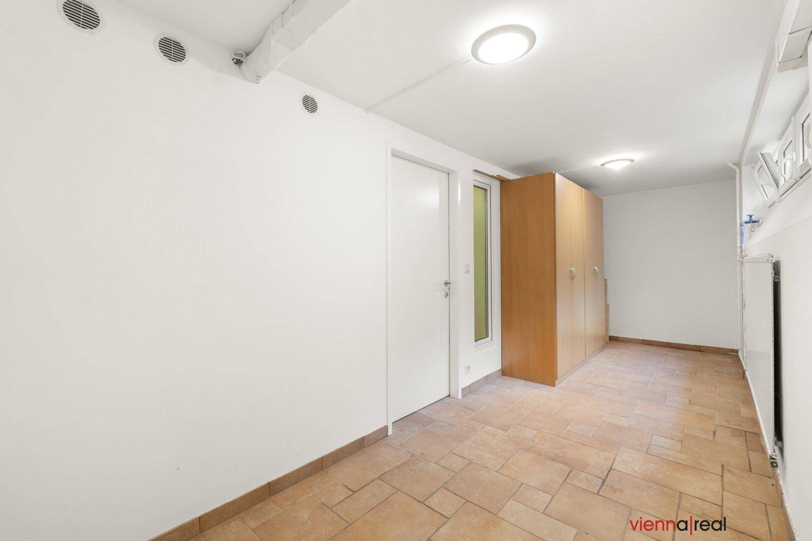 Geräumiger Kellerraum mit Fliesenboden und weißen Wänden, ideal als Abstell- oder Hobbyraum.