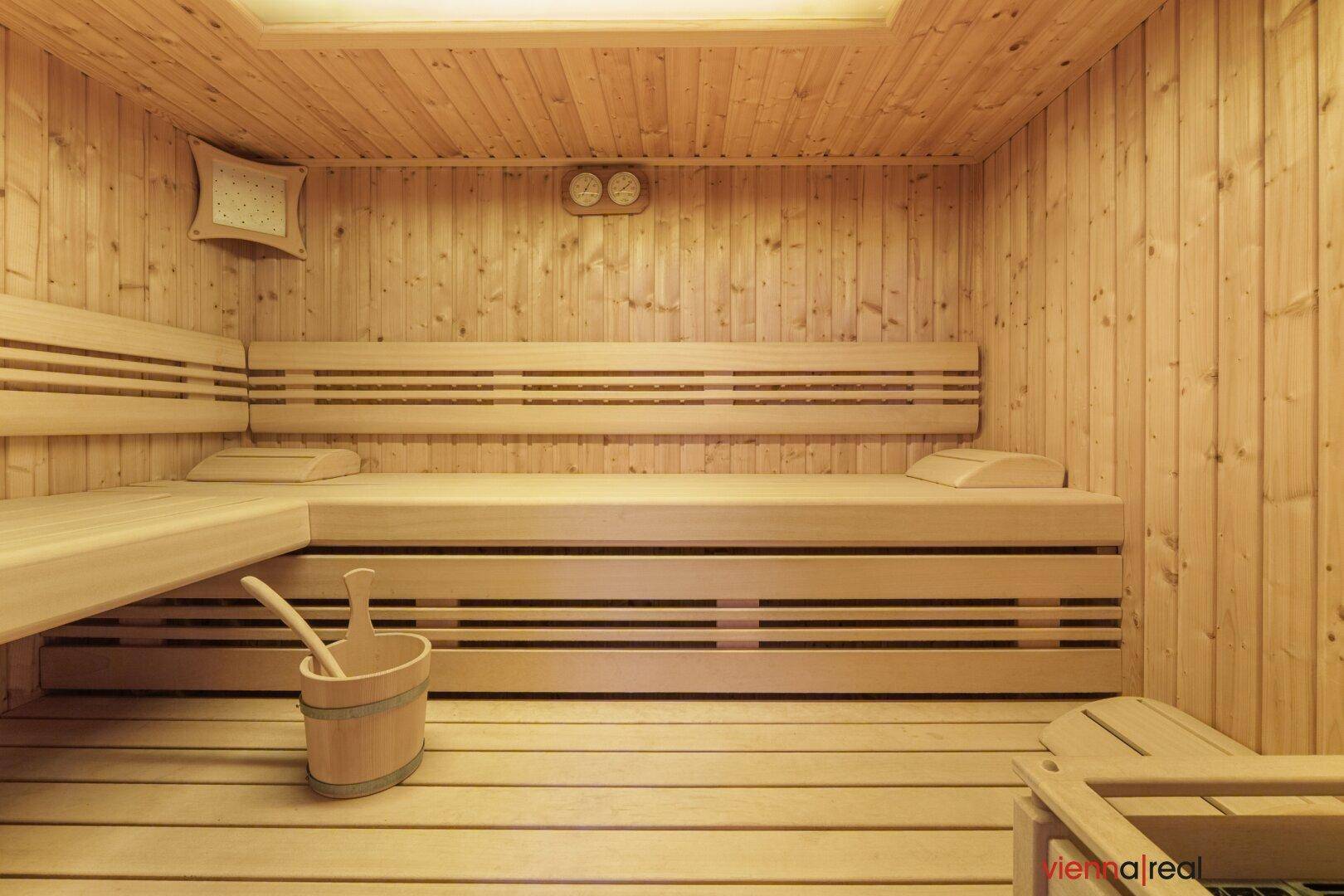 Traditionelle Holzsauna mit Bänken und Saunaeimer, ideal zur Entspannung und Erholung.