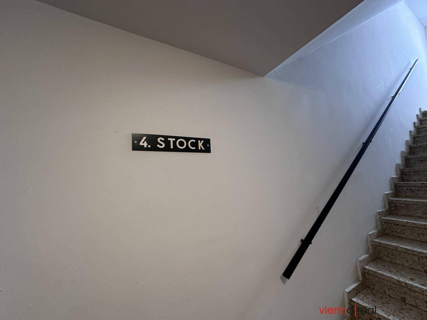Treppenhaus in einem Gebäude mit einem Schild, das den vierten Stock anzeigt.