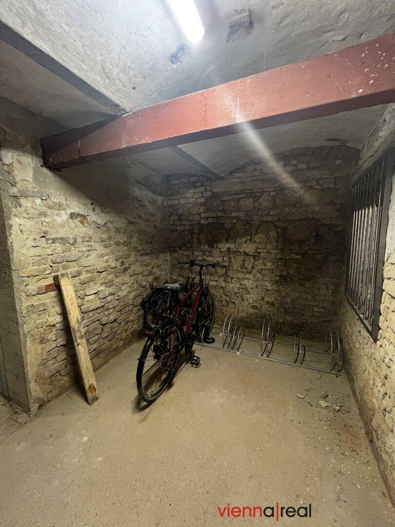 Funktionaler Kellerraum mit unverputzten Ziegelwänden, Betonboden und praktischem Fahrradabstellplatz.