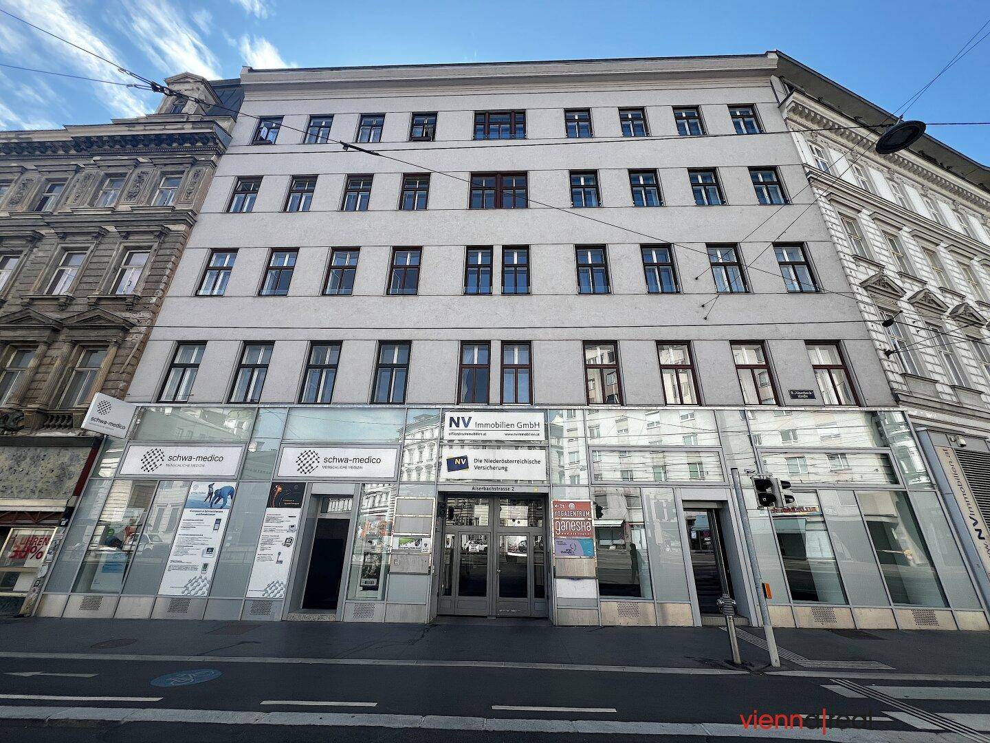 Gesamtansicht der Geschäftsfassade an einer belebten Straße, umgeben von städtischer Architektur.
