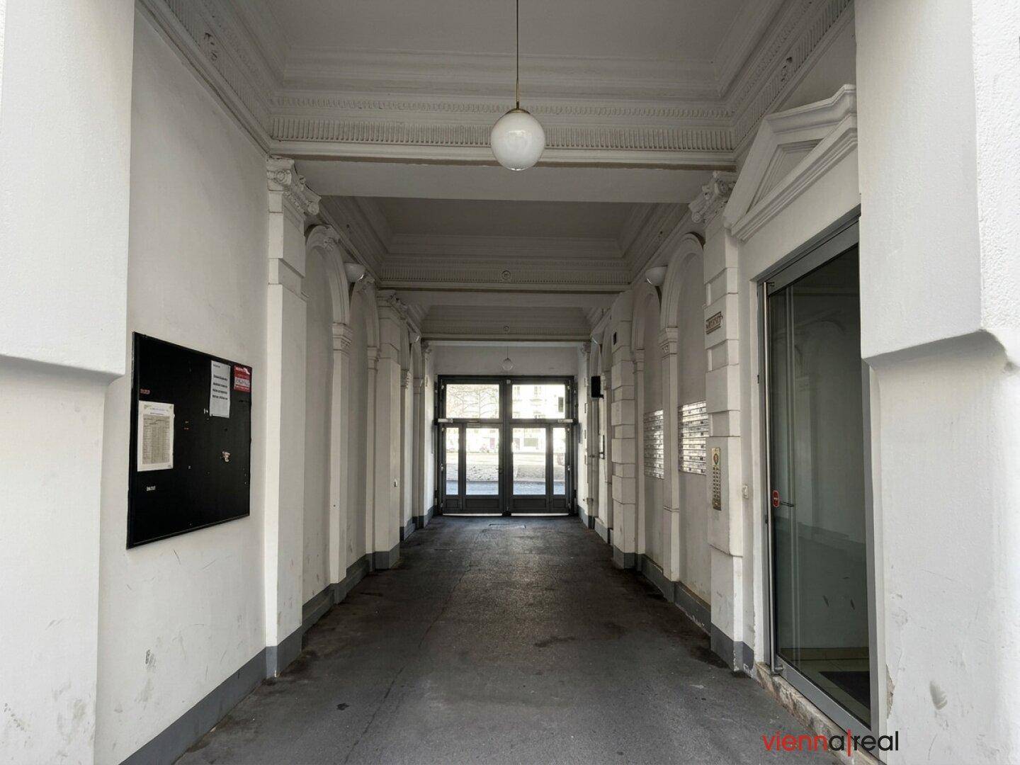Prunkvoller Eingangsbereich mit hohen Decken, Stuckverzierungen und klassischer Architektur.