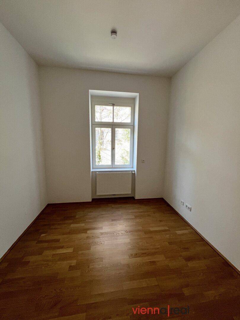 Gemütliches Zimmer mit Parkettboden und einem Fenster, ideal als Schlaf- oder Arbeitszimmer.