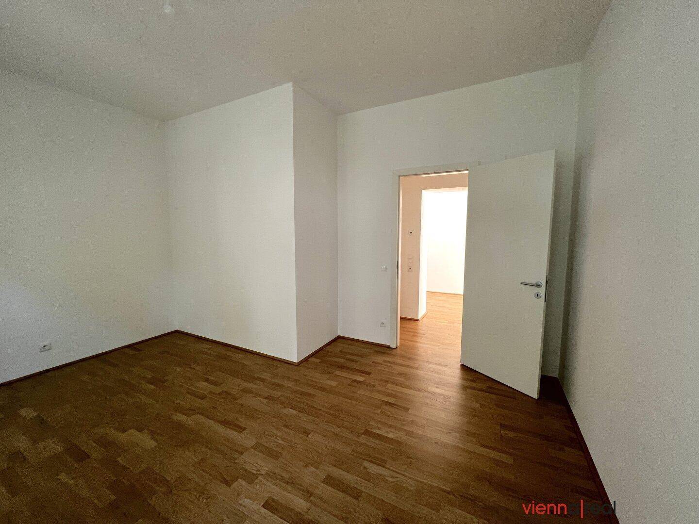 Helles Zimmer mit Parkettboden und weiß gestrichenen Wänden, ideal für flexible Nutzung.