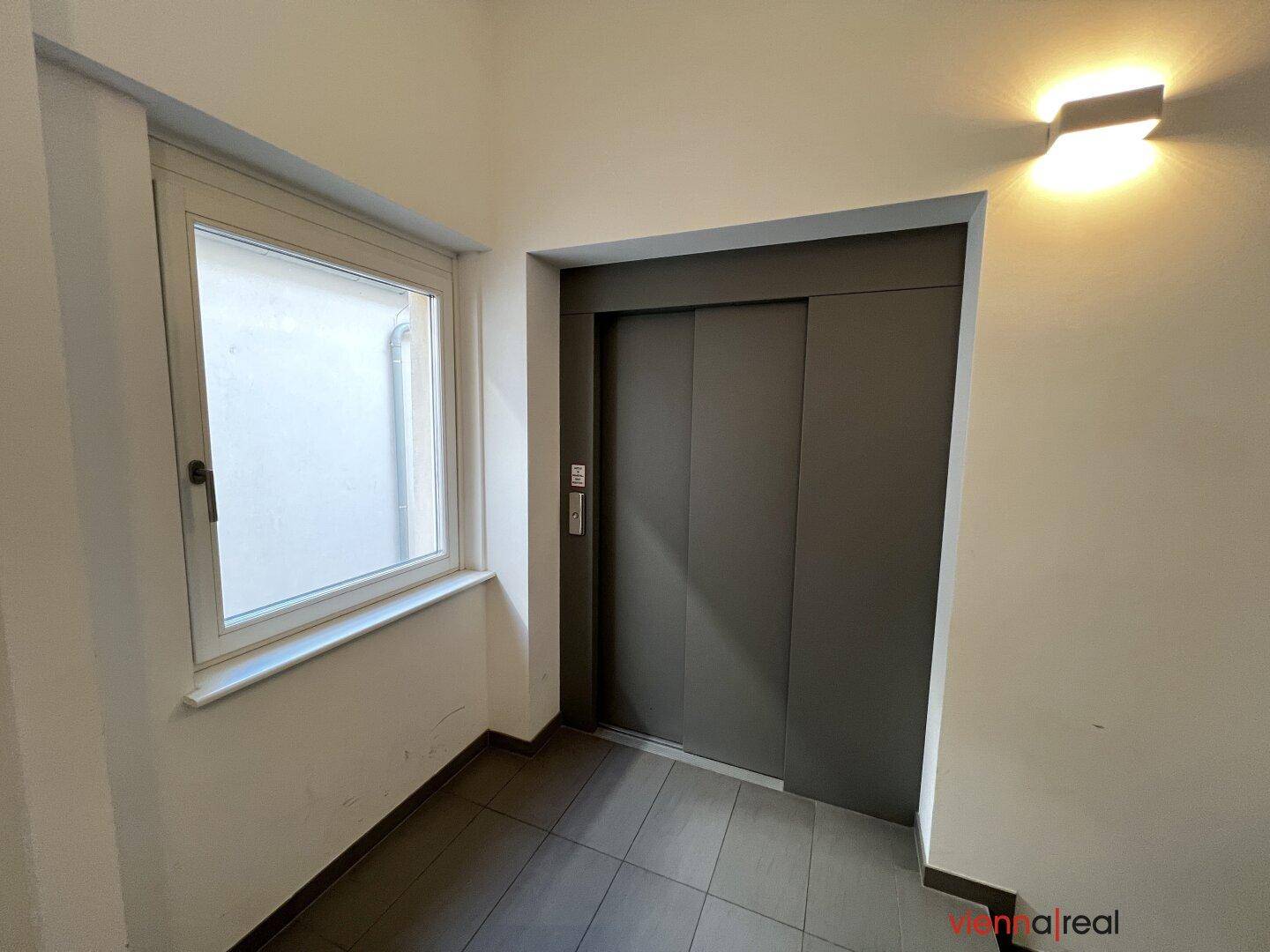 Moderner Aufzug im Gebäude mit Fenster im Flurbereich.
