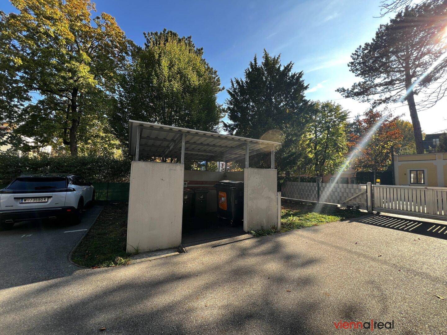 Überdachter Bereich für Mülltonnen und Abfallentsorgung auf dem Grundstück.