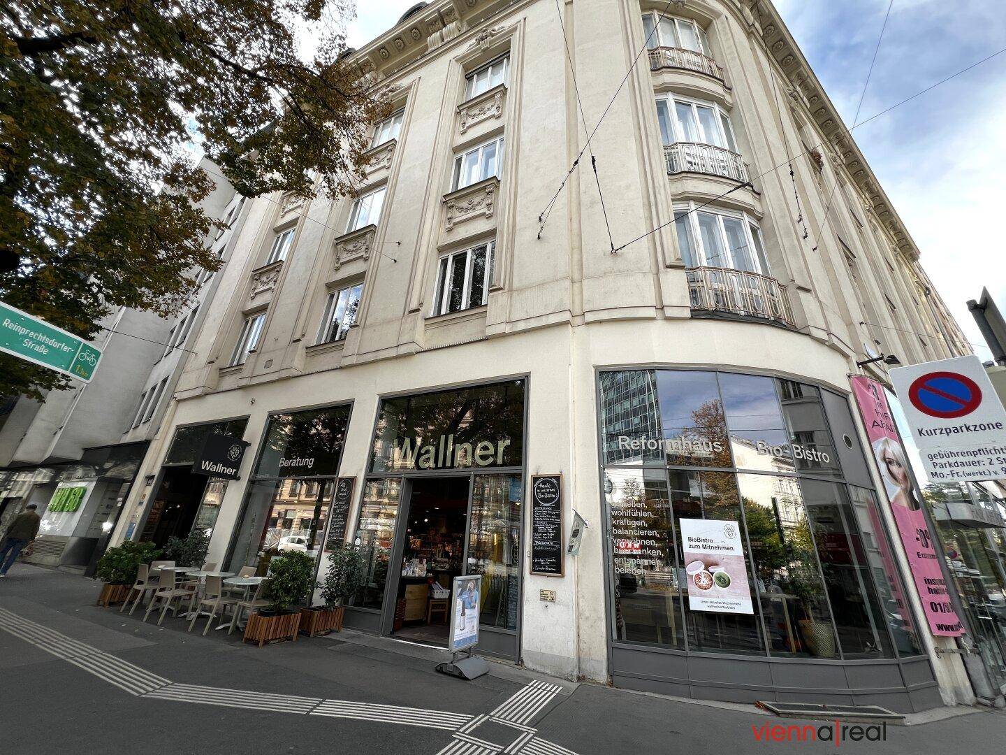 Historisches Eckgebäude mit Geschäften im Erdgeschoss und Wohnungen darüber.