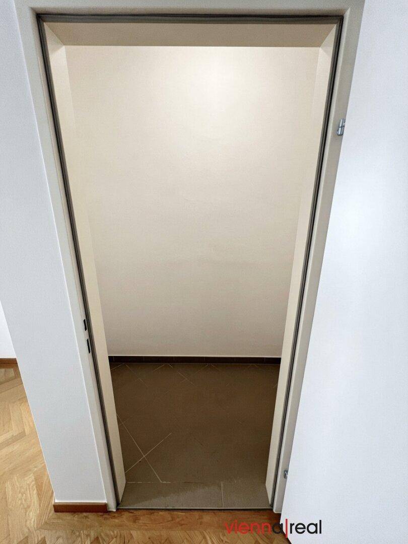 Blick durch eine Tür in einen kleinen, leeren Raum mit Fliesenboden.