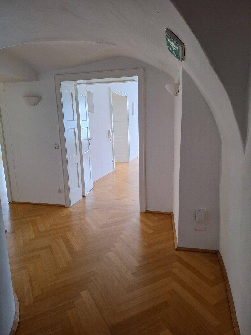 Heller Flur mit gewölbter Decke und Fischgrätparkett, der zu weiteren Räumen führt.
