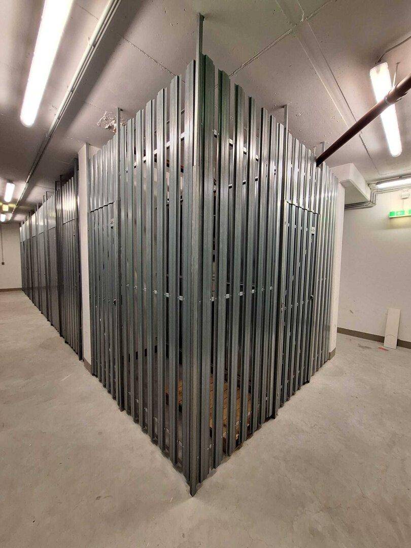Kellerabteil mit Metallgittern für zusätzlichen Stauraum im Untergeschoss.