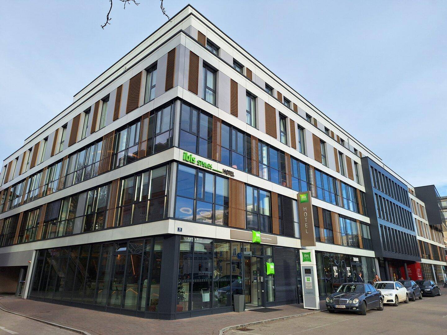 Moderne Eckfassade eines Hotelgebäudes mit großen Glasflächen und zeitgenössischer Architektur.