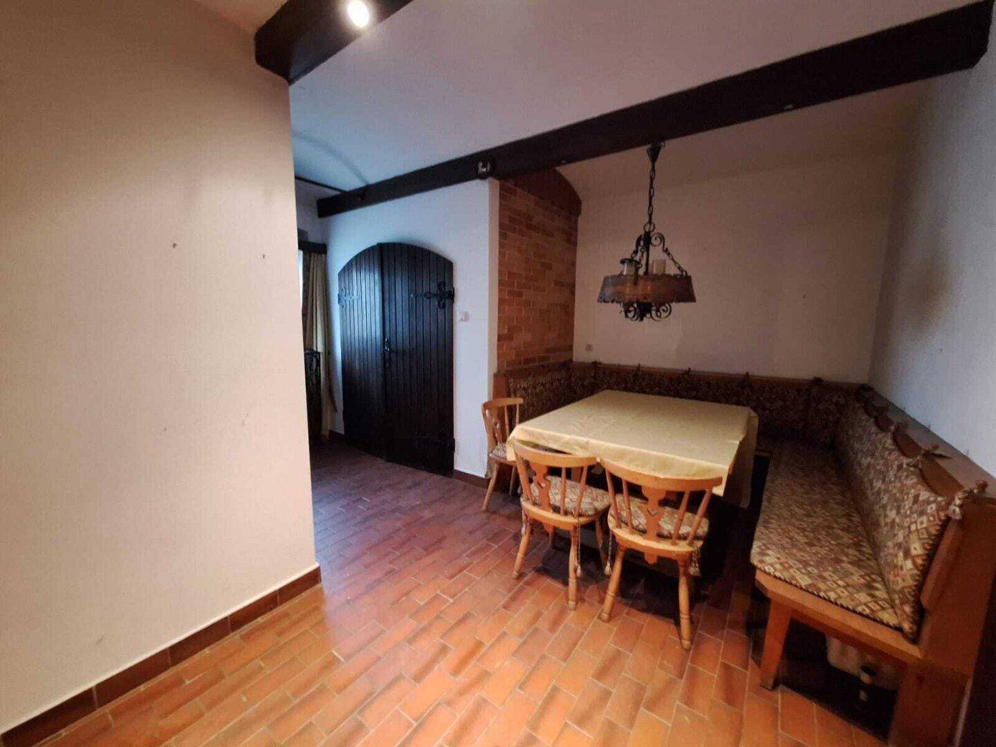 Gemütlicher Essbereich mit traditionellen Holzmöbeln und Terrakotta-Fliesenboden.