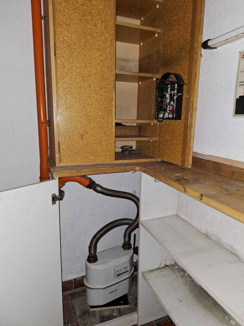 Kleiner Abstellraum mit Gaszähler und Rohrleitungen, praktisch für technische Installationen.
