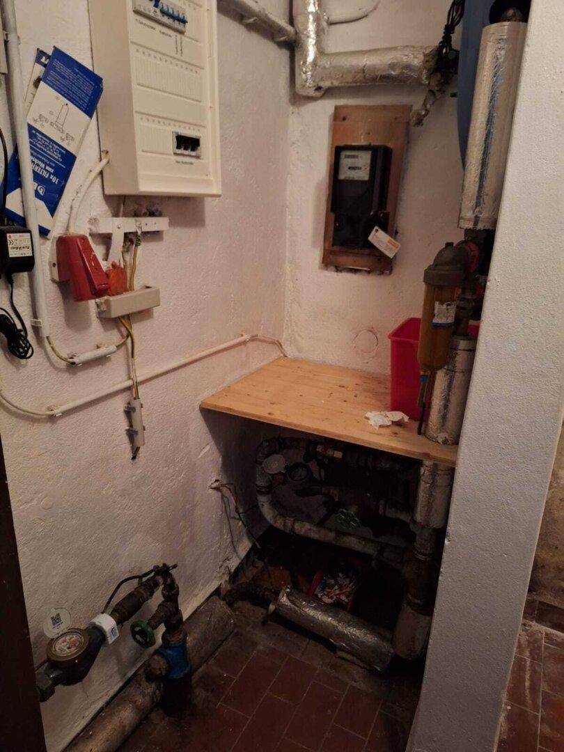 Technikraum mit Sicherungskasten, Rohren und Zähler in einem funktionalen Bereich.