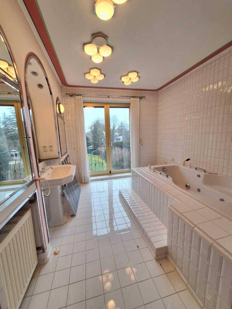 Wendeltreppe mit grünem Teppichbelag und Holzgeländer, führt nach unten, im Vintage-Stil.