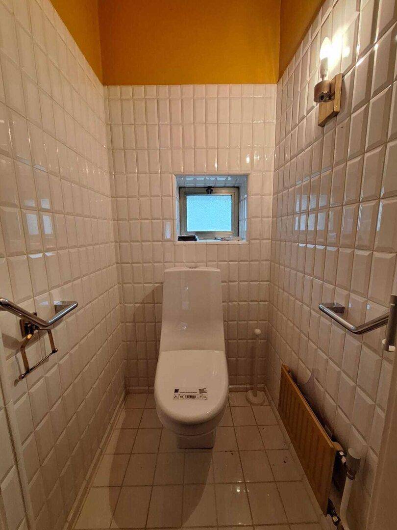 Geräumiger Kellerraum mit Fliesenboden und gelben Wänden, ideal als Lager oder Werkstatt.