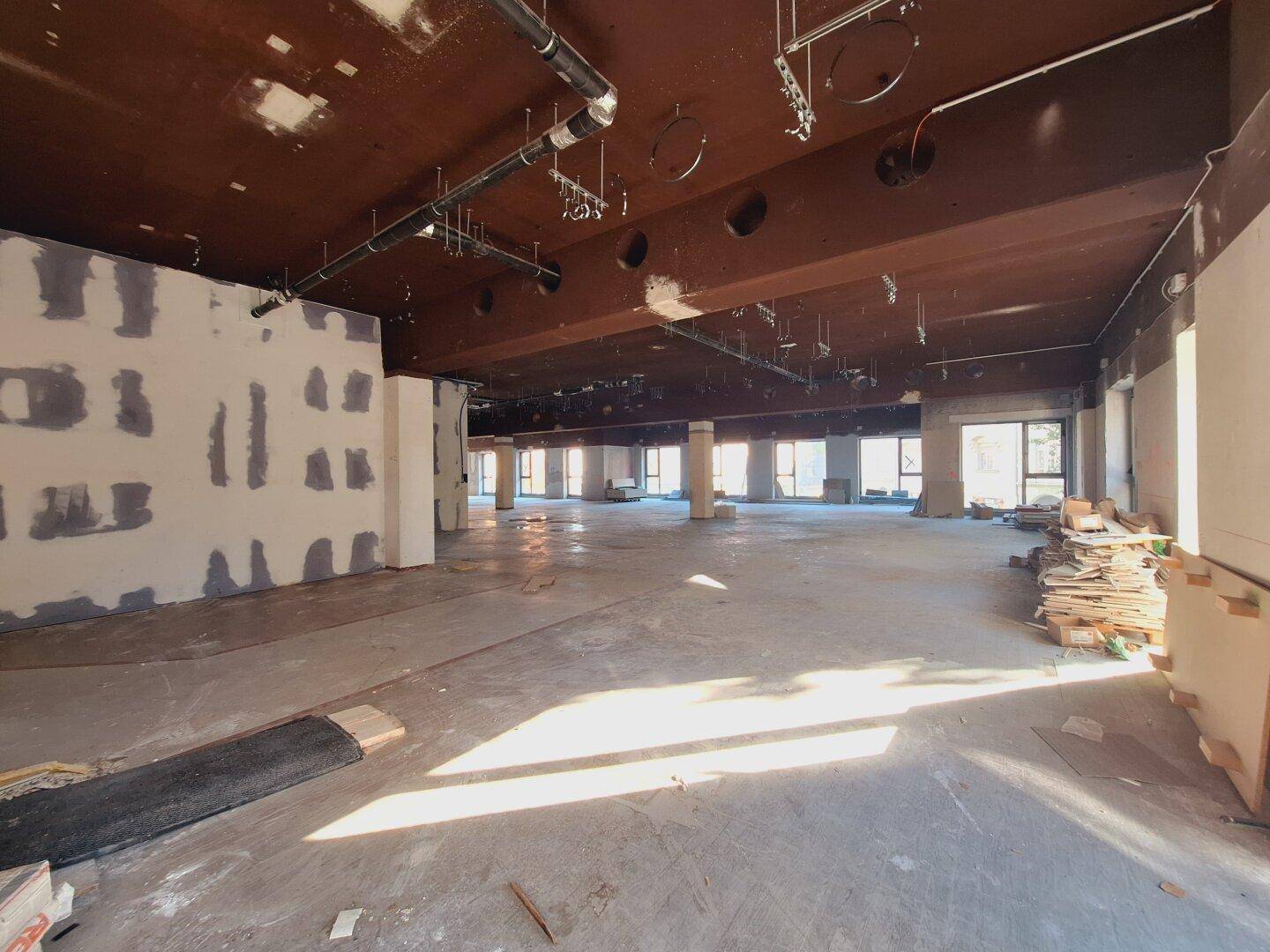 Heller Gewerberaum im Rohbau mit sichtbaren Deckeninstallationen und viel Potenzial für individuelle Gestaltung.