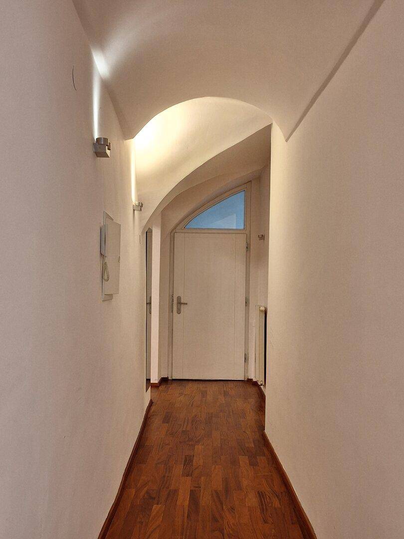 Kleines Gäste-WC mit schwarz-weiß kariertem Fliesenboden, wandhängendem WC und Handwaschbecken.