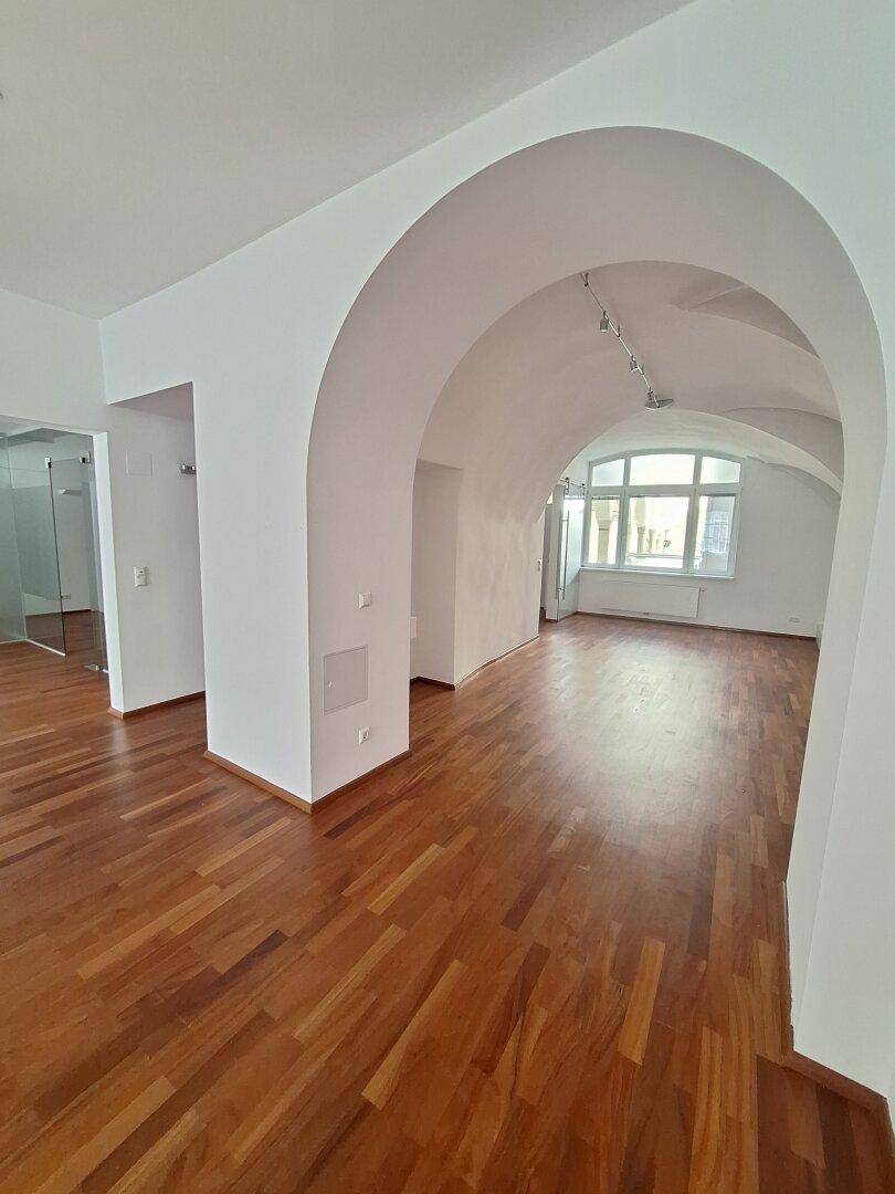Heller Flur mit zwei weißen Türen, die zu den Toilettenbereichen führen.