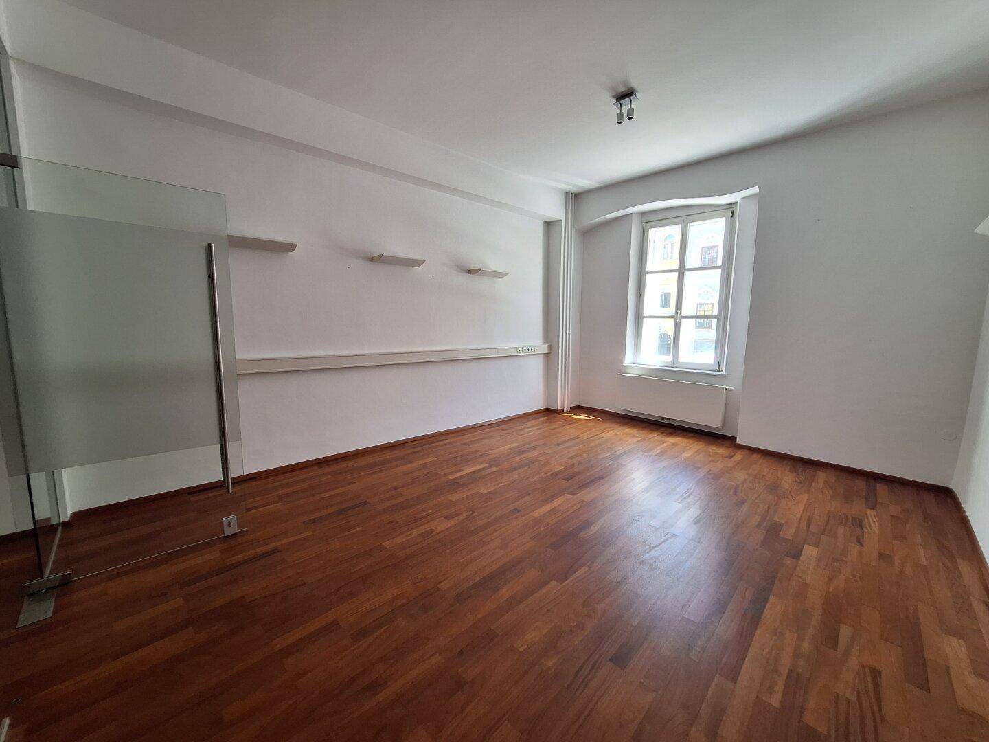 Kleiner Technikraum mit Serverschrank und Verkabelung, umgeben von modernen Schiebetüren.