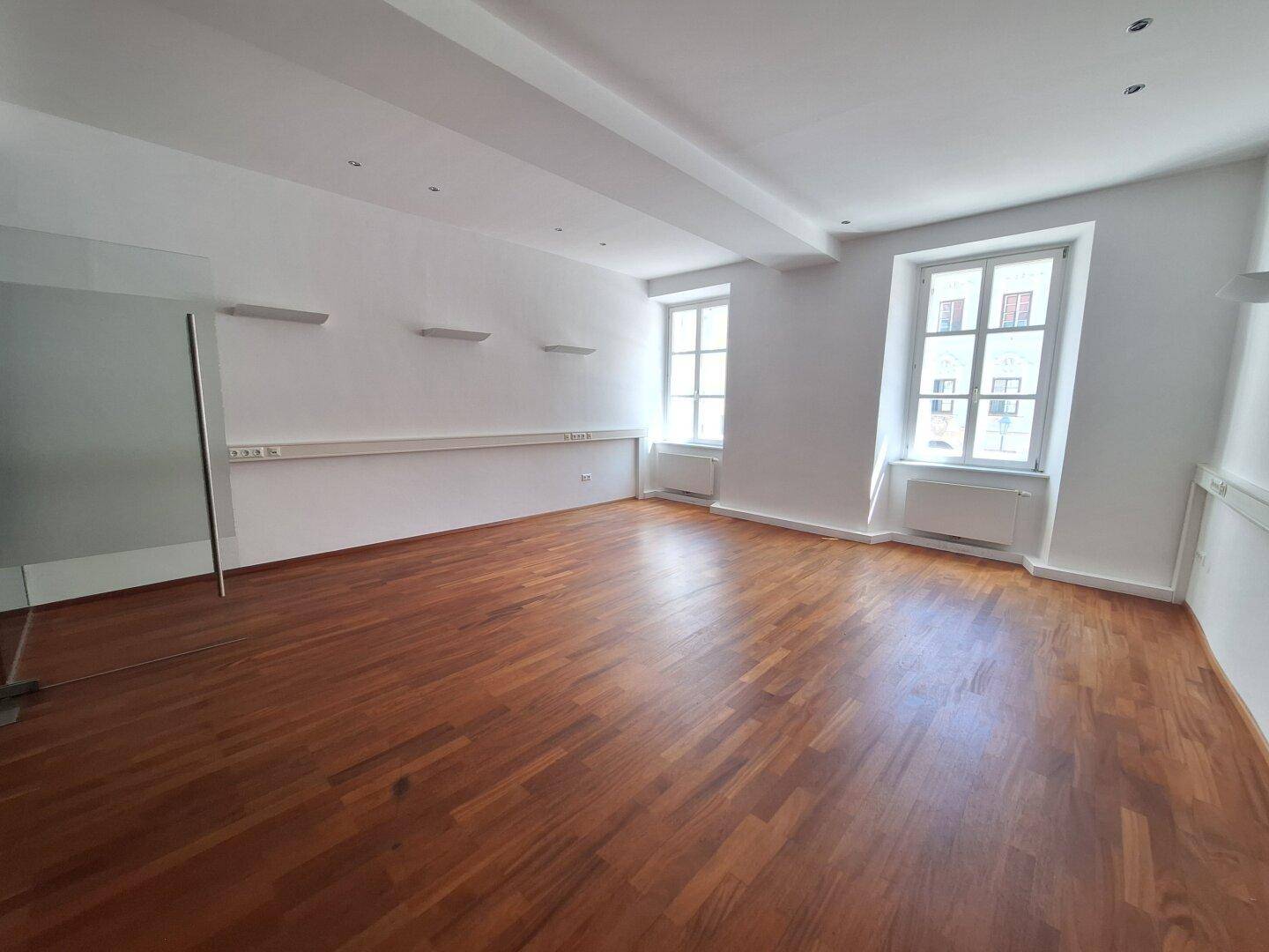 Großer Büroraum mit beeindruckenden Gewölbedecken und großen Fenstern, die viel Tageslicht hereinlassen.