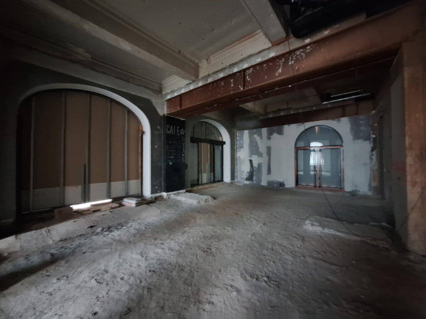 Innenraum in Renovierung mit charakteristischen Rundbögen und sichtbaren Rohbau-Elementen, die auf eine zukünftige Nutzung warten.