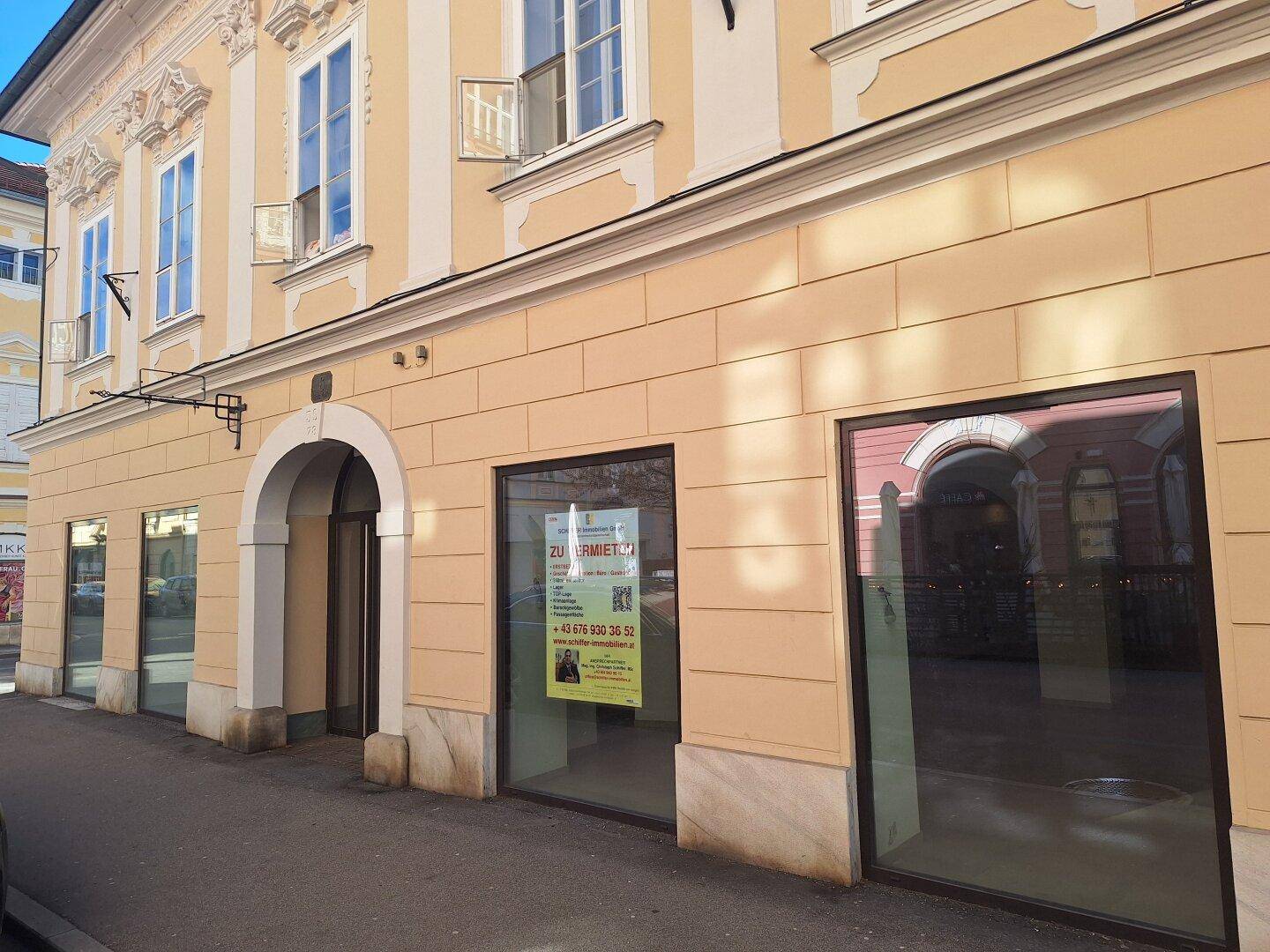 Nahaufnahme der historischen Fassade mit Schaufenstern und einem 'Zu Vermieten' Schild an der Ecke.
