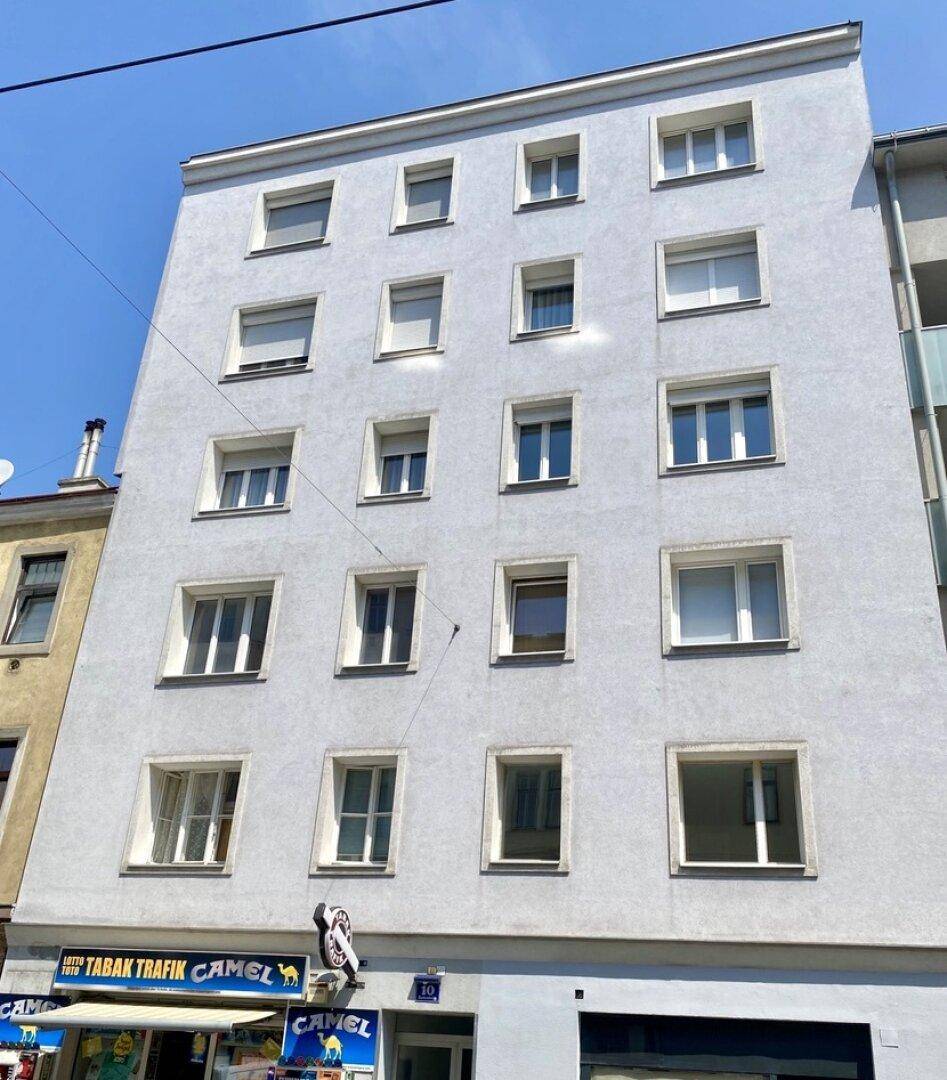 Mehrstöckiges Wohngebäude mit schlichter Fassade und vielen Fenstern.