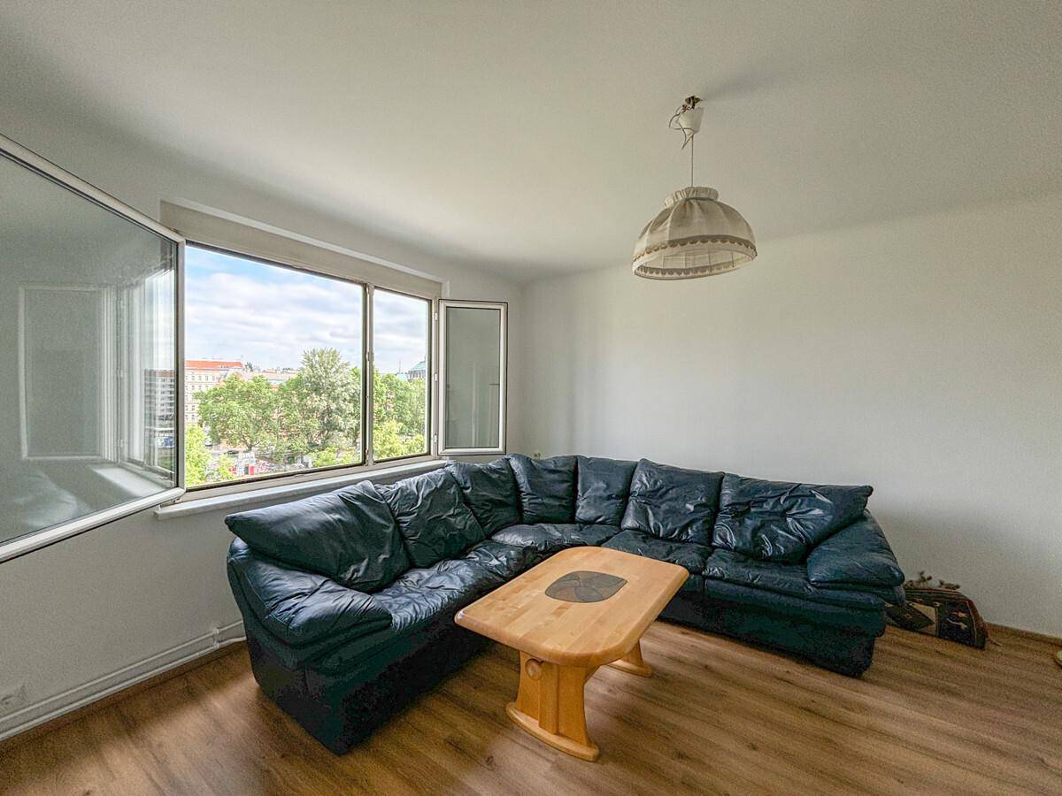 Gemütliches Wohnzimmer mit großem Ecksofa, Holztisch und weitem Blick aus den Fenstern.