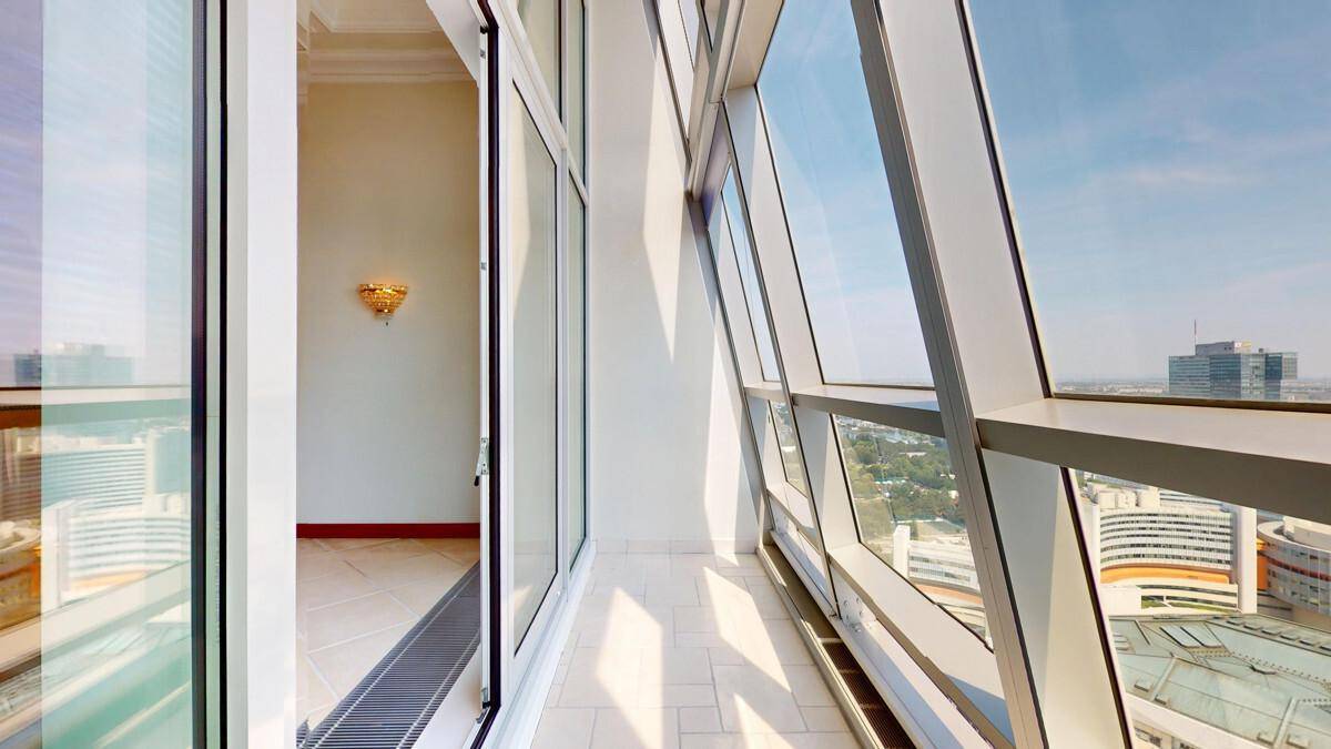 Helle Loggia mit Fliesenboden und weitem Blick auf die umliegende Stadt.