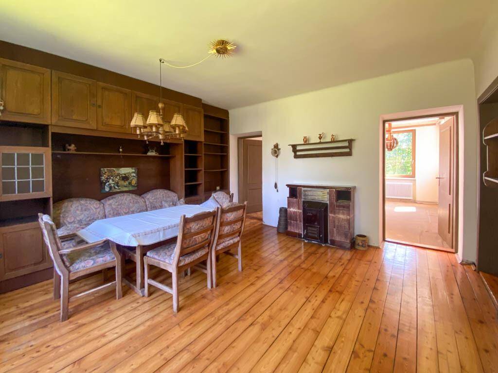 Geräumiges Esszimmer mit Holzdielenboden, großem Esstisch und traditionellen Holzmöbeln.