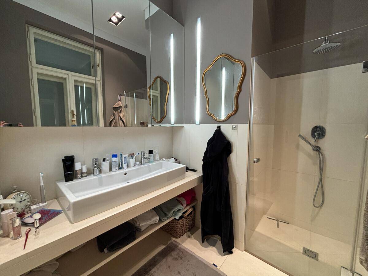 Modernes Badezimmer mit großer Dusche, Einzelwaschbecken und Spiegelschrank.