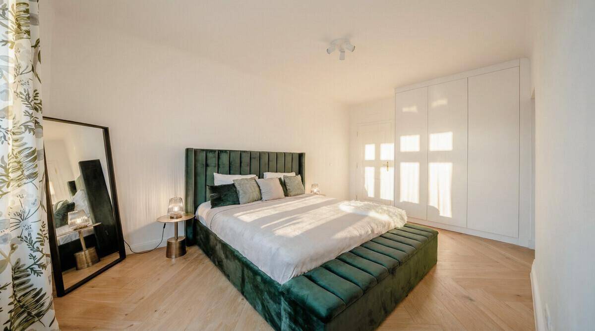 Stilvolles Schlafzimmer mit großem Bett, Einbauschrank und viel Tageslicht, sehr geräumig.